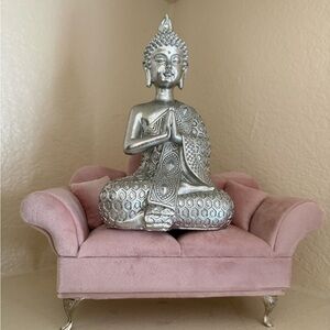 Silver Buddha Statue on Pink Sofa